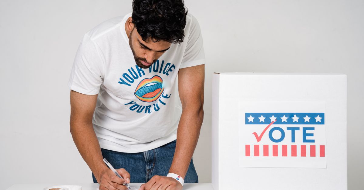 Man filling out ballot at polling station with a focus on civic duty and electoral participation.